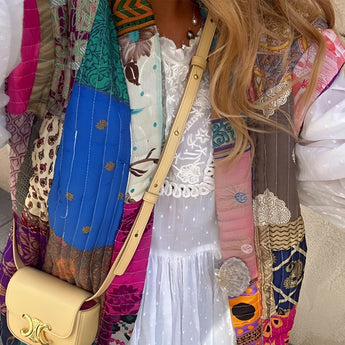 Bohemian embroidered patchwork dress with a vibrant magenta color, featuring intricate patterns and a flattering waistline. The dress has a unique design suitable for artisan summer fashion, highlighting a blend of textile craftsmanship and formal wear elements.