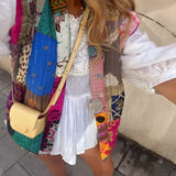 Bohemian Embroidered Patchwork Dress featuring a mix of vibrant pink patterns, intricate embroidery, and a patchwork design. The dress showcases a collar, long sleeves, and a fitted waist, embodying artisan summer fashion with a playful and eclectic style.