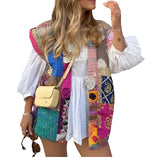 Bohemian embroidered patchwork dress featuring vibrant colors and intricate patterns, highlighting a fitted waist and flowing sleeves, paired with a pink bag.