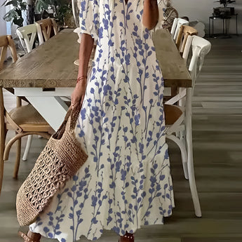 Bohemian Floral Maxi Dress in blue, featuring a V-neck design, worn by a person. The dress is styled as a summer outfit, with long flowing sleeves and a comfortable fit.