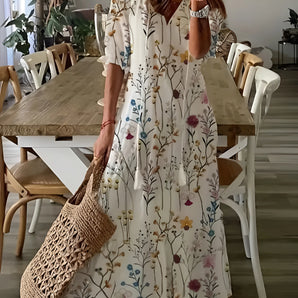 Bohemian floral maxi dress featuring a V-neckline, shown in white color in size 3XL. The dress is displayed on a hanger against a simple background, highlighting its flowing one-piece design and fashionable floral pattern.