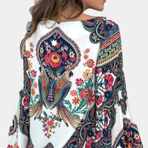 
Women's ethnic blouse with a bohemian floral paisley design, featuring long sleeves and a collar, predominantly white in color.