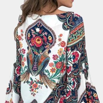
Women's ethnic blouse with a bohemian floral paisley design, featuring long sleeves and a collar, predominantly white in color.