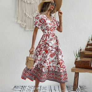 Bohemian floral summer dress in white and red, featuring a mid-length wrap design with short sleeves, displayed on a standing mannequin.