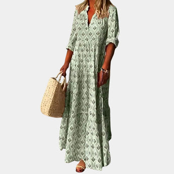 Bohemian light blue V-neck maxi dress featuring a geometric tribal print, with long sleeves and a fitted waist, styled for a casual day look.