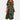 Colorful abstract print bohemian midi dress in green, featuring a loose fit ideal for summer. The dress is knee-length, with short sleeves and a scoop neckline, modeled by a person standing outdoors.
