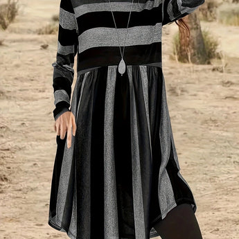 A woman smiling and wearing a Bohemian multi-color striped tunic dress with long sleeves, in black, size 7XL(58).