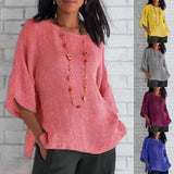 
A woman wearing a Bohemian oversized linen tunic, featuring a casual summer blouse style in a light pink color. The blouse has a relaxed fit with flowing sleeves and a round neckline, showcasing a fashionable and comfortable design suitable for warm weather.