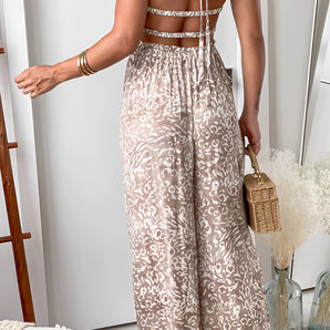 Bohemian Paisley Jumpsuit with strappy open back and wide legs, featuring a paisley pattern, sleeveless design, and a relaxed fit.