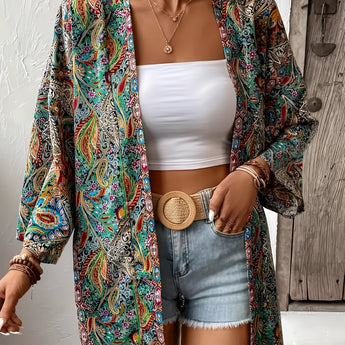 Bohemian Paisley Kimono worn by a model, showcasing a colorful summer jacket and beach cover-up with intricate paisley patterns. The model pairs it with sunglasses, emphasizing a fashionable and relaxed summer look. The kimono features flowing sleeves and a loose fit that drapes elegantly over the shoulders and waist.