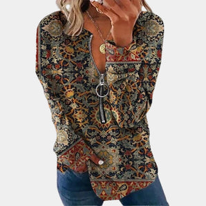 
A woman wearing a green Bohemian Paisley zipper V-neck sweater, size XL, with long sleeves, standing with her hands on her waist.