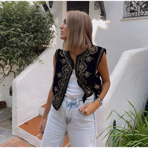 Bohemian women's black vest with intricate gold embroidery, styled as luxury ethnic summer outerwear, showcasing a sleeveless design and highlighting shoulder and waist details.