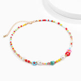 Multicolored pearl boho bead choker necklace featuring floral and trendy designs, displayed on a creative arts background.
