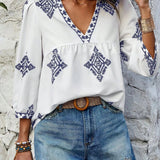 Boho Chic Ethnic Print Blouse featuring a V-neck design, displayed in a summer-appropriate style with short sleeves and a relaxed fit, showcasing a vibrant ethnic pattern on a white fabric.