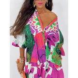 Boho chic long sleeve maxi dress featuring an abstract print with vibrant pink and violet colors, showcasing design elements such as a defined waist, stylish collar, and elegant shoulder and neck details.
