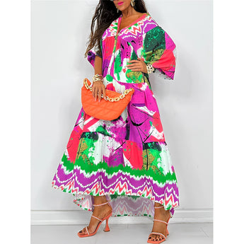 Boho chic long sleeve maxi dress with a vibrant abstract print in shades of pink and magenta, featuring a defined waist and flowing design suitable for spring fashion.