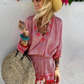 Boho Chic Patterned Pink Fringe Dress worn by a woman outdoors, featuring a bohemian design with fringes, in a red color. The dress has short sleeves and a relaxed fit suitable for summer beachwear. The woman appears happy and is accessorized with sunglasses.