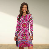 Boho Chic Tribal Print A-Line Knee-Length Dress in Pink, featuring a vibrant tribal pattern, modeled by a smiling woman. The dress has long sleeves and a flattering A-line silhouette, perfect for fall fashion. The model stands near greenery, highlighting the dress's bohemian style.