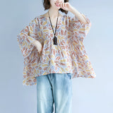 Boho Chic V-Neck Blouse with Leaf Pattern featuring wide sleeves, modeled by a woman with an elegant hairstyle, showcasing the shoulder and waist design.