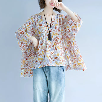 Boho Chic V-Neck Blouse with Leaf Pattern featuring wide sleeves, modeled by a woman with an elegant hairstyle, showcasing the shoulder and waist design.