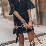 Boho-Chic V-Neck Mini Dress in a black and white pattern, featuring a flowing design with a fitted waist and sleeves. The dress is styled as a summer dress and beach cover-up, ideal for warm weather outings. The dress is presented on a model, showcasing its flattering V-neckline and short hemline.