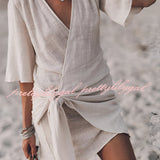 Boho-Chic V-Neck Mini Dress being worn, showcasing its fashionable design with a focus on the V-neckline, waistline detail, and short sleeves ideal for summer or as a beach cover-up.