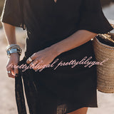 Boho-Chic V-Neck Mini Dress in black, featuring short sleeves, a fitted waist, and a stylish design suitable for summer outings and beach cover-ups, modeled outdoors paired with sunglasses.