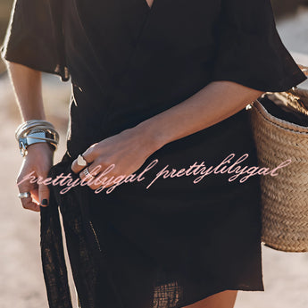 Boho-Chic V-Neck Mini Dress in black, featuring short sleeves, a fitted waist, and a stylish design suitable for summer outings and beach cover-ups, modeled outdoors paired with sunglasses.