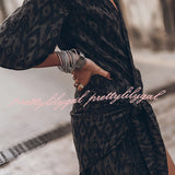 Boho-chic V-neck mini dress with a summer vibe, featuring a black and white tartan pattern, short sleeves, and a flattering waistline, suitable as a beach cover-up.