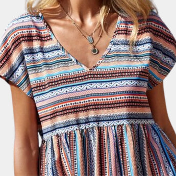 Boho Chic V-Neck Tribal Pattern Blouse featuring a vibrant Aztec design, shown in azure blue. The top has short sleeves and a relaxed fit, highlighting the intricate textile patterns suitable for summer fashion.