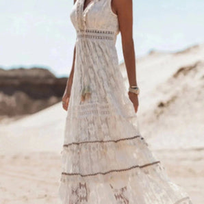 Boho Chic White Lace Maxi Dress worn by a bride, featuring intricate lace detailing on the shoulders and sleeves, perfect for a summer beach wedding.