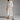 White lace midi dress with floral crochet design, featuring a V-neck, short sleeves, and a fitted waist. The dress is styled in a boho chic fashion and is displayed in size 2XL.