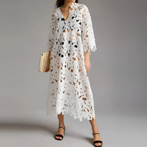 White lace midi dress with floral crochet design, featuring a V-neck, short sleeves, and a fitted waist. The dress is styled in a boho chic fashion and is displayed in size 2XL.