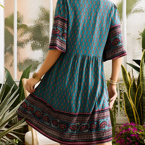 Boho ethnic print V-neck knee-length dress with three-quarter sleeves, featuring a vibrant pattern.