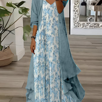 Boho Floral Maxi Dress with Cardigan in teal, featuring an asymmetrical two-piece design. The dress is displayed in a blue color, size XXL, highlighting its jointed style with distinct shoulder and neck details. It is surrounded by a white background, with a plant in a flowerpot nearby.