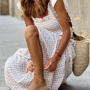 Boho Gingham Maxi Dress with a smocked square neck design, featuring a flowy silhouette ideal for summer fashion. The dress is predominantly white and includes distinctive style elements such as puffed sleeves and a defined waistline.