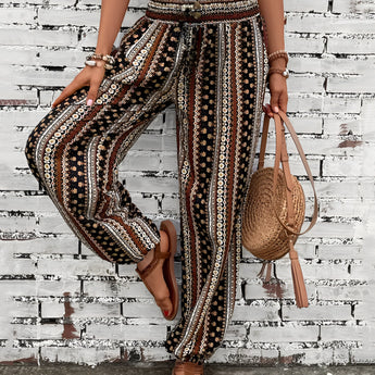 Boho Women's Tribal Print Wide Leg Festival Pants worn by a person, showcasing a colorful tribal pattern and a relaxed wide-leg fit. The image captures parts of the person's legs and hints at a casual, bohemian style suitable for festivals.