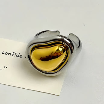 Bold gold adjustable statement ring featuring a large reflective amber heart-shaped gemstone.