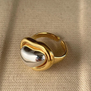 Bold gold adjustable statement ring featuring a large reflective gemstone.
