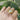 A hand adorned with a bold gold adjustable statement ring featuring a large reflective gemstone on the finger.