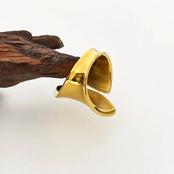 Bold gold statement ring with a modern, sculptural design, showcasing designer craftsmanship in jewelry.
