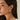 A pair of bold textured gold leaf statement earrings worn by a model, highlighting designer fashion jewelry.