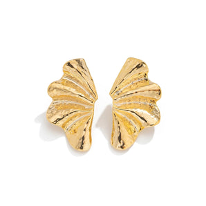 Bold Textured Gold Leaf Statement Earrings with butterfly wing design pattern, showcasing intricate metal craftsmanship and designer fashion jewelry details on a wooden background.