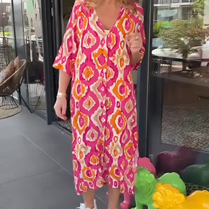 Bright floral V-neck kaftan dress featuring a vibrant mix of green and pink hues, designed as a one-piece garment with flowing sleeves and a relaxed fit, suitable as a summer beach coverup.