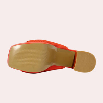 Bright orange ankle boots with a stretch fit sock design and neon heel detail, featuring a synthetic rubber sole.