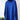 Bright blue oversized turtleneck sweater with long sleeves and a cozy knit design, displayed against a natural background with plants.