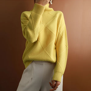 Woman wearing a bright yellow geometric knit high neck sweater with long sleeves, suitable for winter fashion.