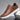 Dark brown low-top men's sneakers made of leather with a stylish design, featuring a versatile white sole.