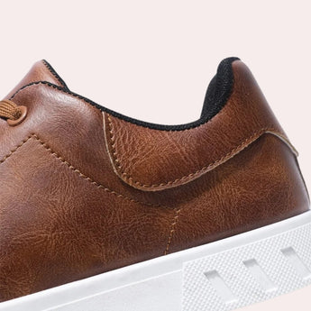 Brown leather men's low-top sneakers with a white sole, designed for outdoor and walking purposes, showcasing a stylish and versatile look.