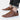 Men's brown leather low-top sneakers with a stylish design and white sole, paired with denim pants.